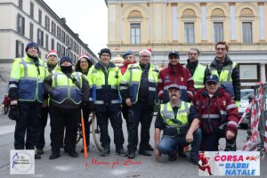 Foto di gruppo con due volontari dell'associazione Volontari Polizia di Stato alla Corsa dei Babbi Natale